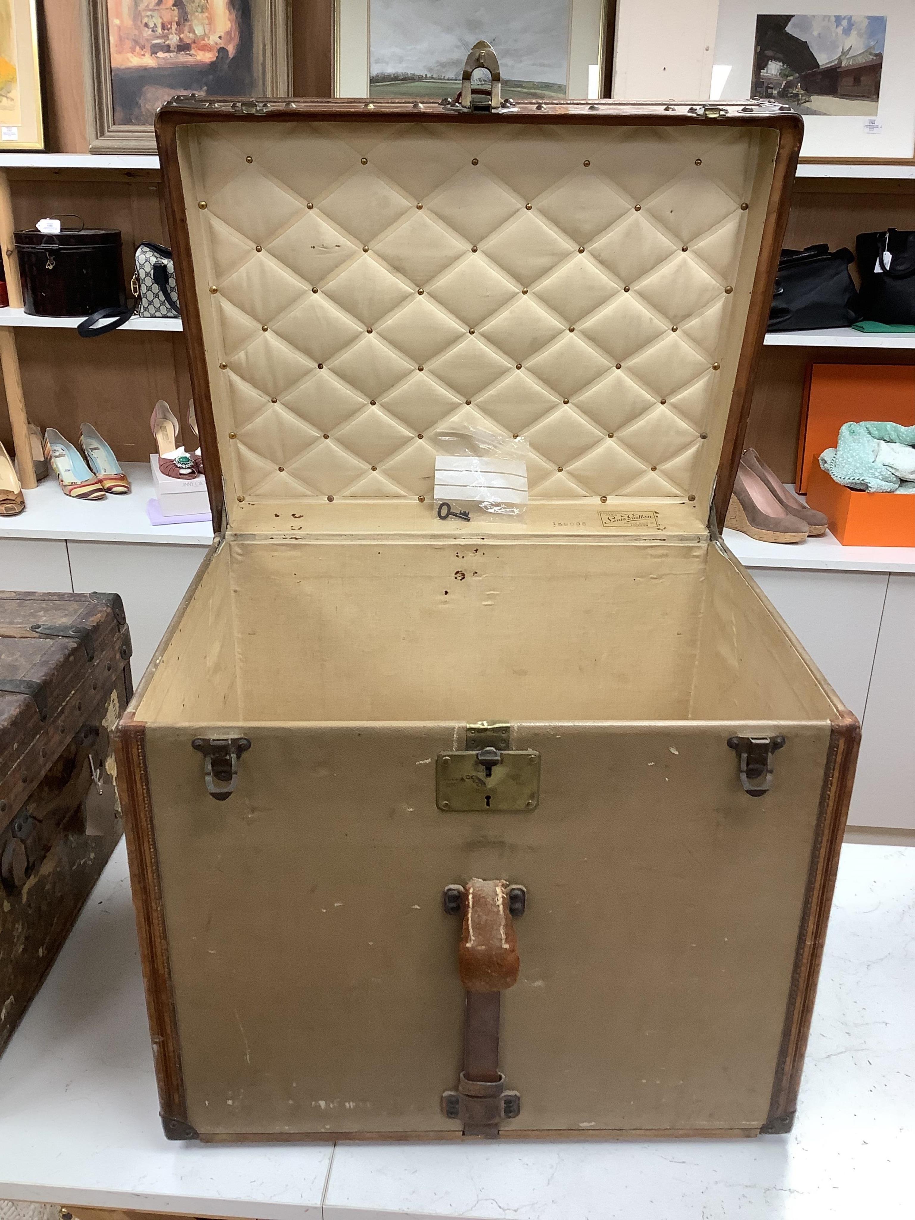 A vintage Louis Vuitton trunk, with brass and leather mounts and studded wooden slats, in plain beige canvas, with label for Paris and London, number 159008, 61cm wide, 48cm deep, 53cm high